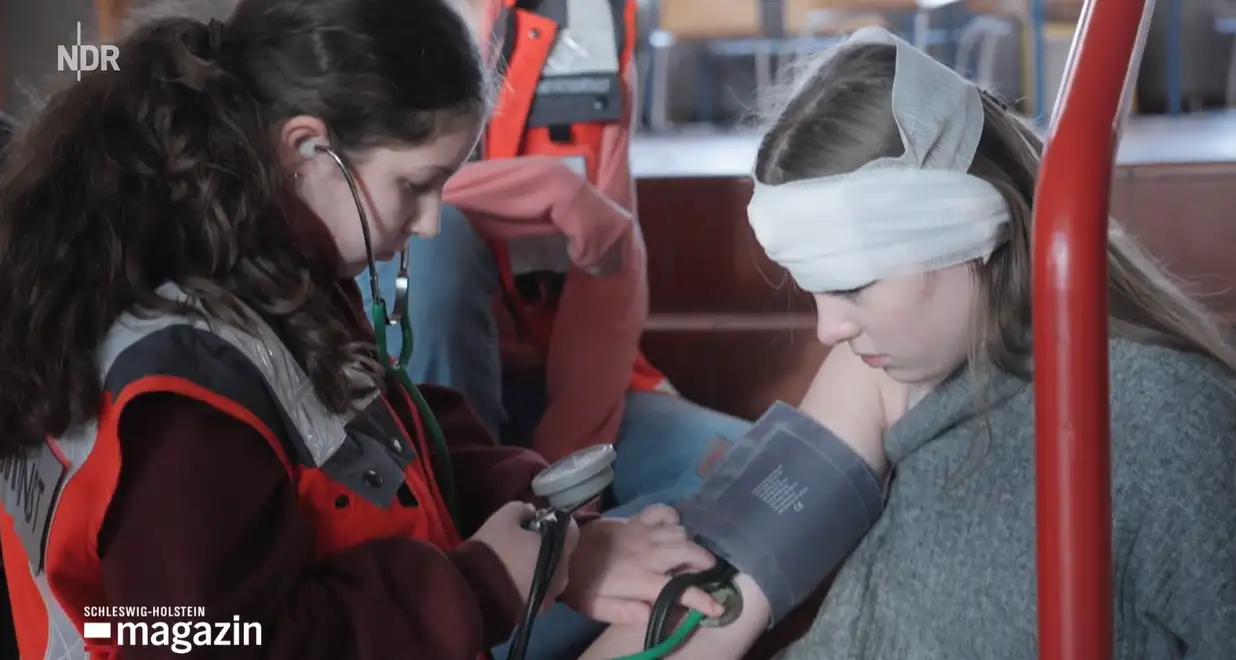 Schulsanitäterin Nora verarztet in einer Übung die verletzte Schülerin Julika