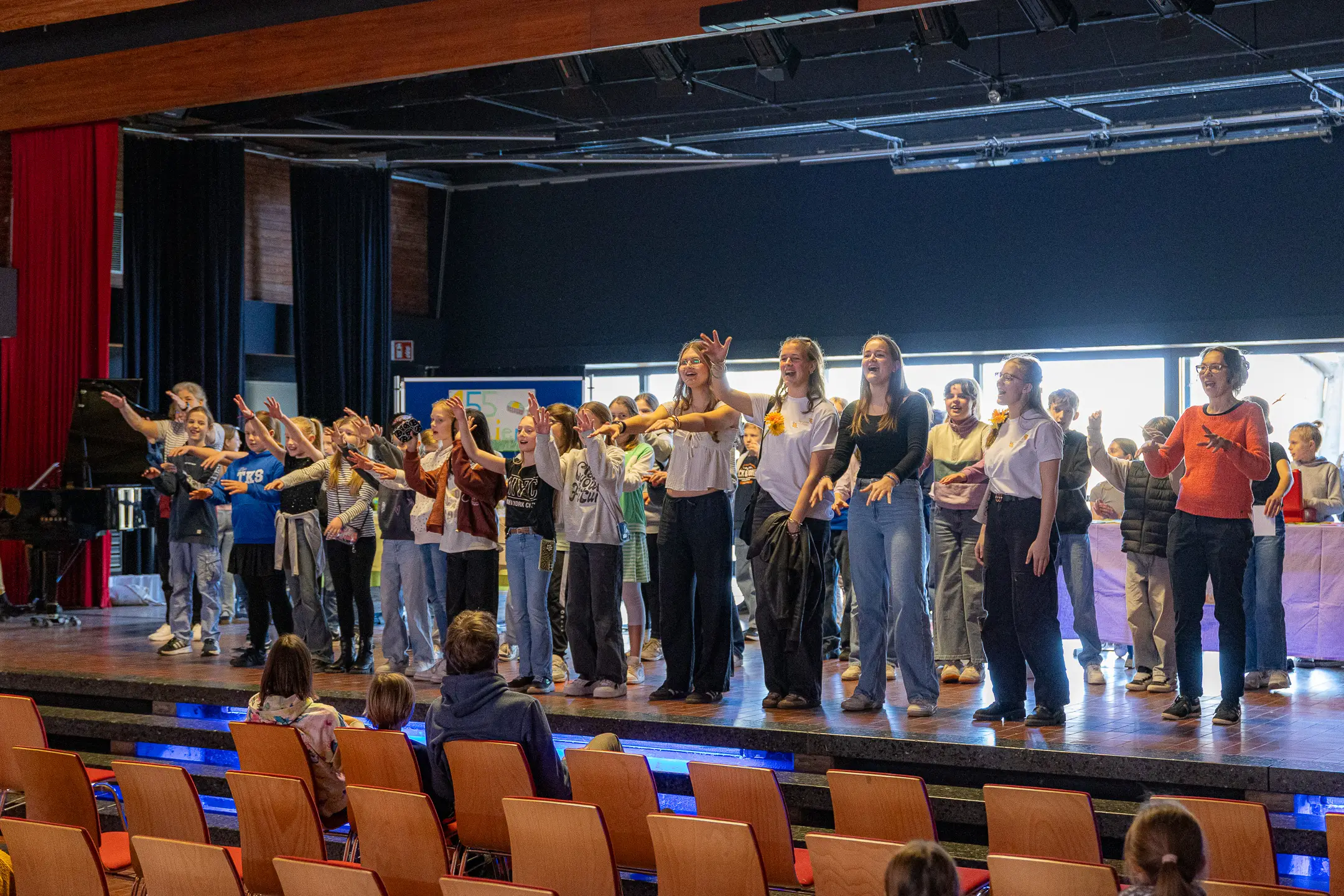 Eine Gruppe aus Schuelerinnen und Schuelern, sowie Lehrkräften performt die EBS-Hymne "Die Zeit ist jetzt"